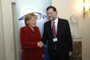 A chanceleresa alemá, Angela Merkel, e o presidente do PP español, Mariano Rajoy, esta cuarta feira en Varsovia